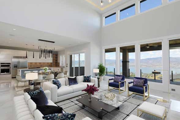 The same open plan living space staged with two white sofas, blue armchairs, a coffee table, a rug and a potted palm